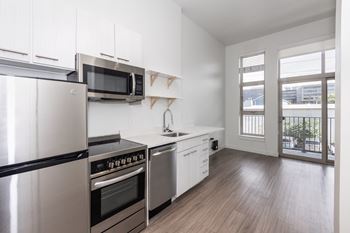 A kitchen with stainless steel appliances and white cabinets.